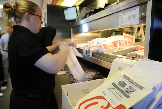 A Chick-fil-A team member loads up orders at the restaurant near Southlands Mall in Aurora. Denver Council is debating on whether to let the restaurant chain return to DIA. (Andy Cross, The Denver Post)